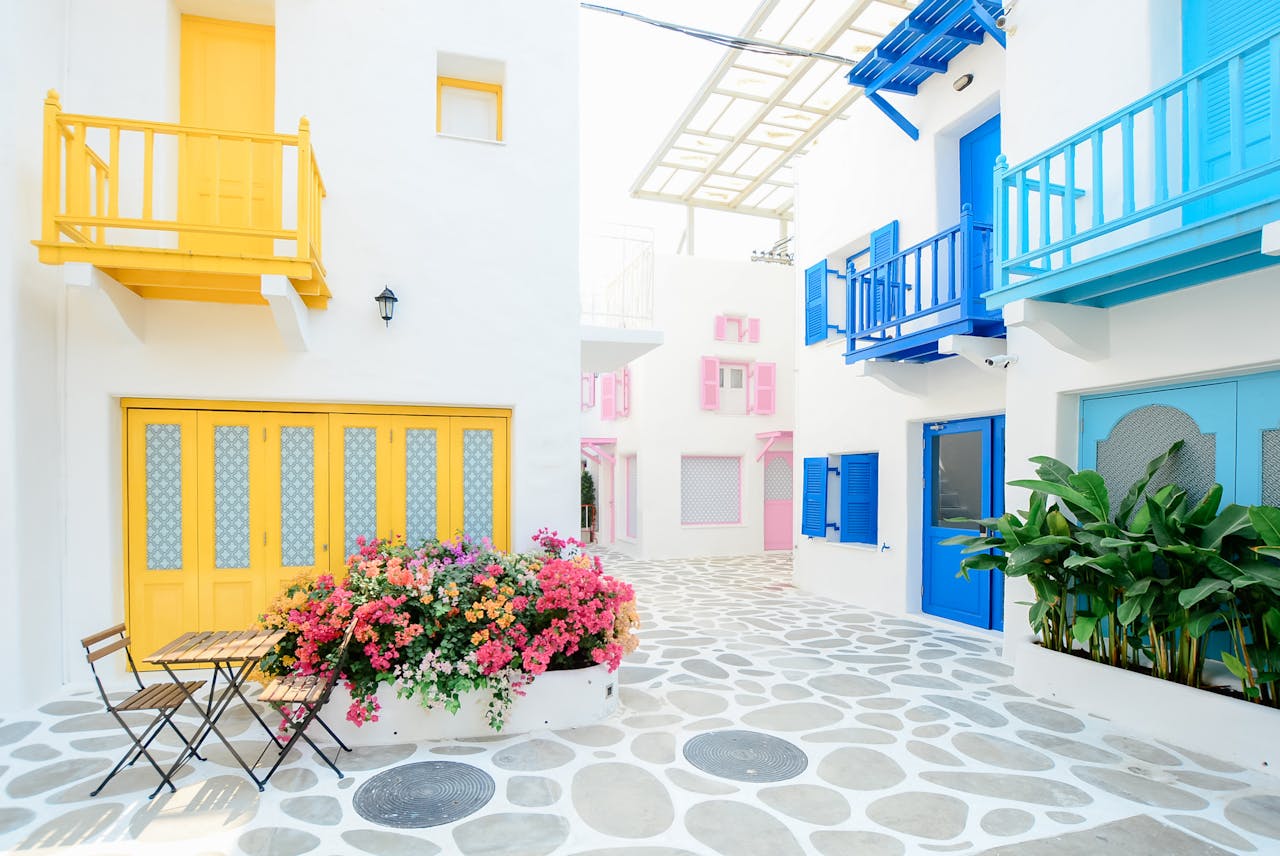 portfolio-04 Vibrant Mediterranean architecture with colorful doors and balconies in Greece.