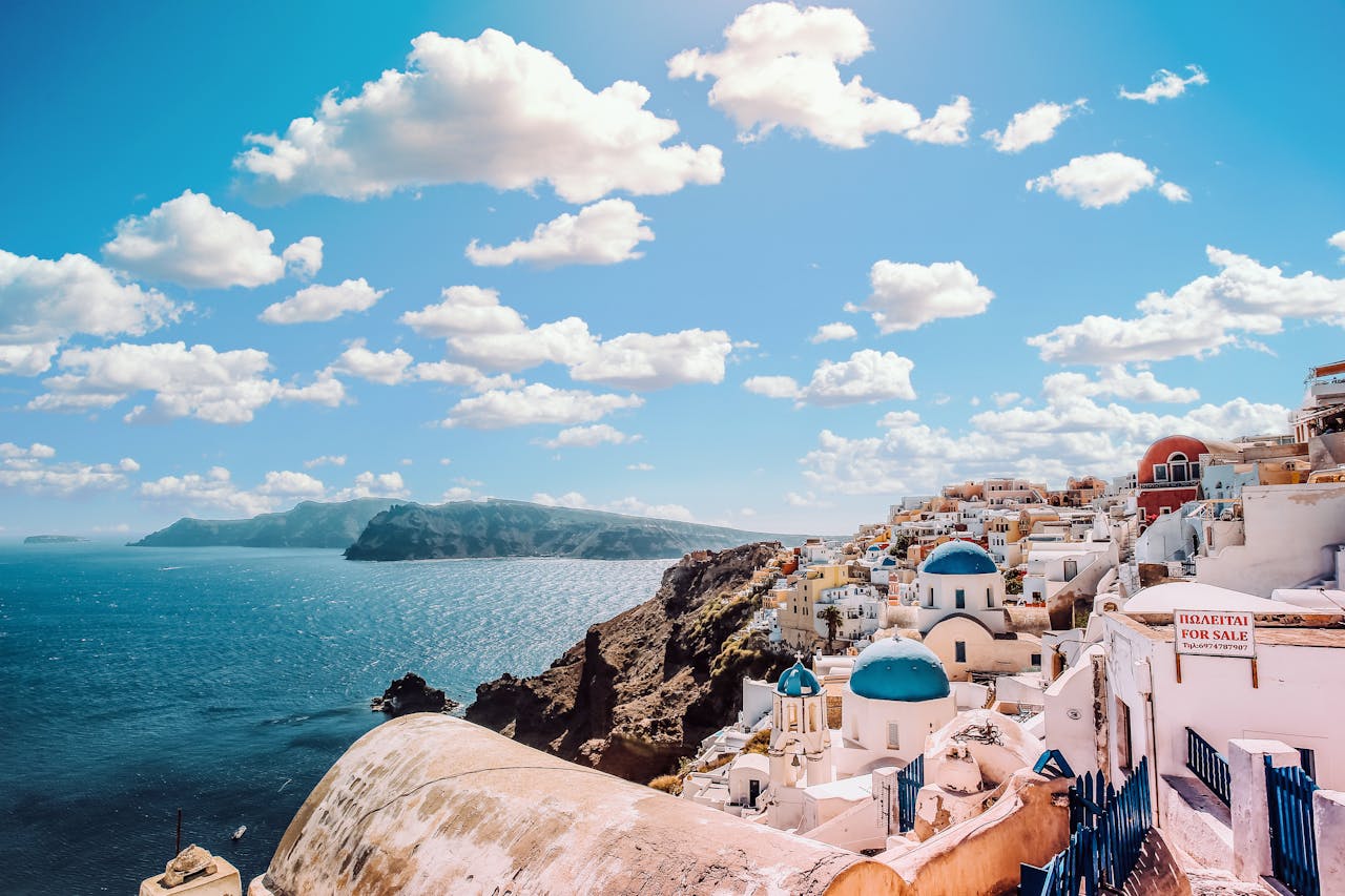 portfolio-06 Captivating view of Santorinis famous blue-domed buildings under a vibrant sky.